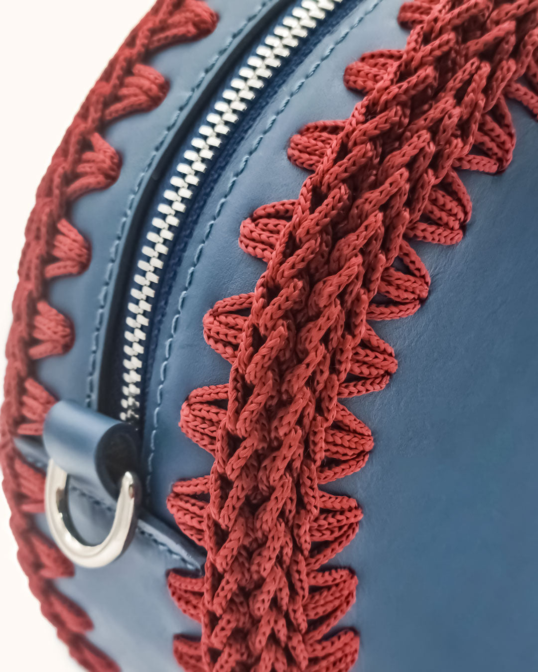 Bolso redondo pequeño artesanal azul de cuero y crochet hecho a mano por Cueché